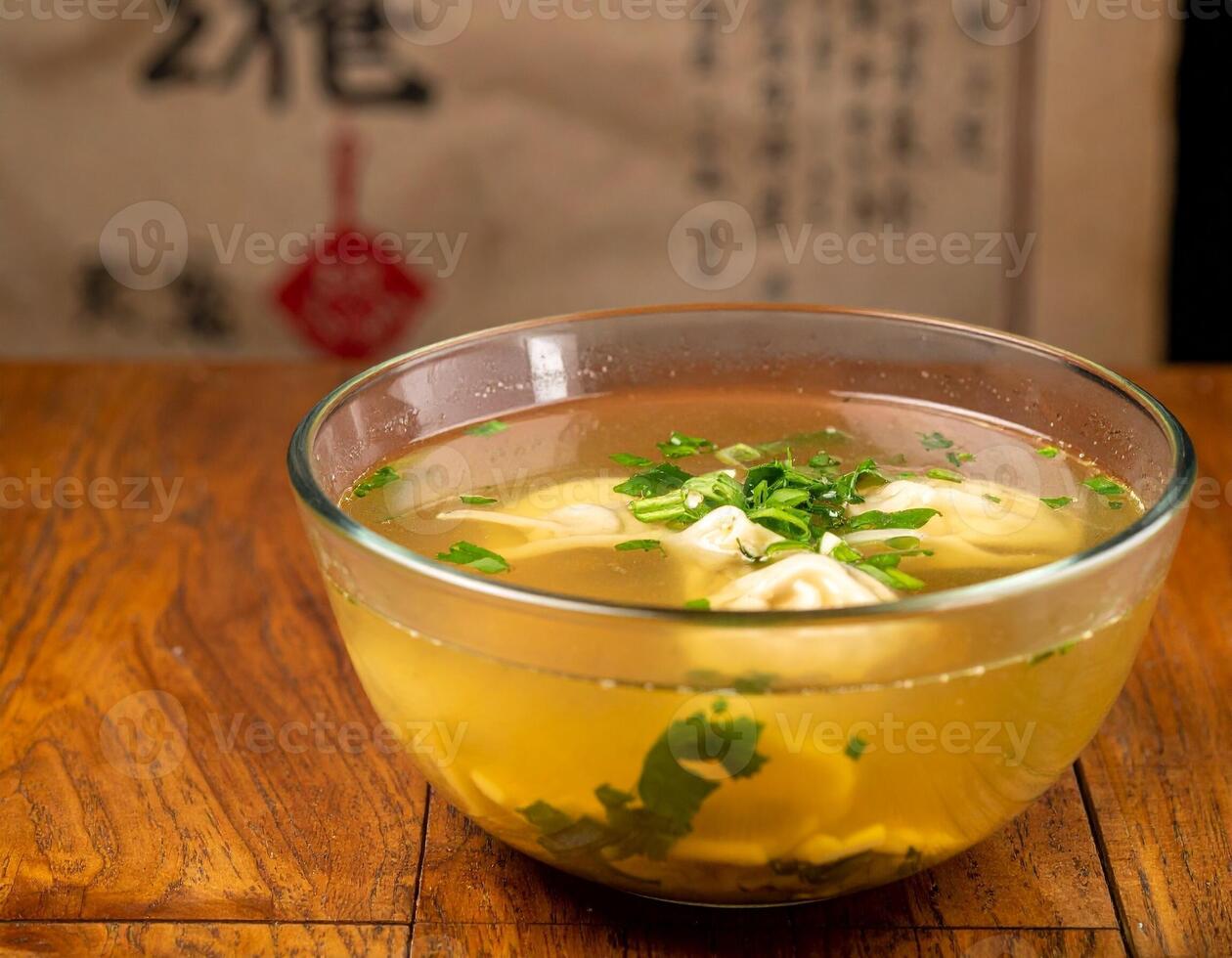 Delicious Wonton Soup with Dumplings and Broth Served in a Clear Bowl photo