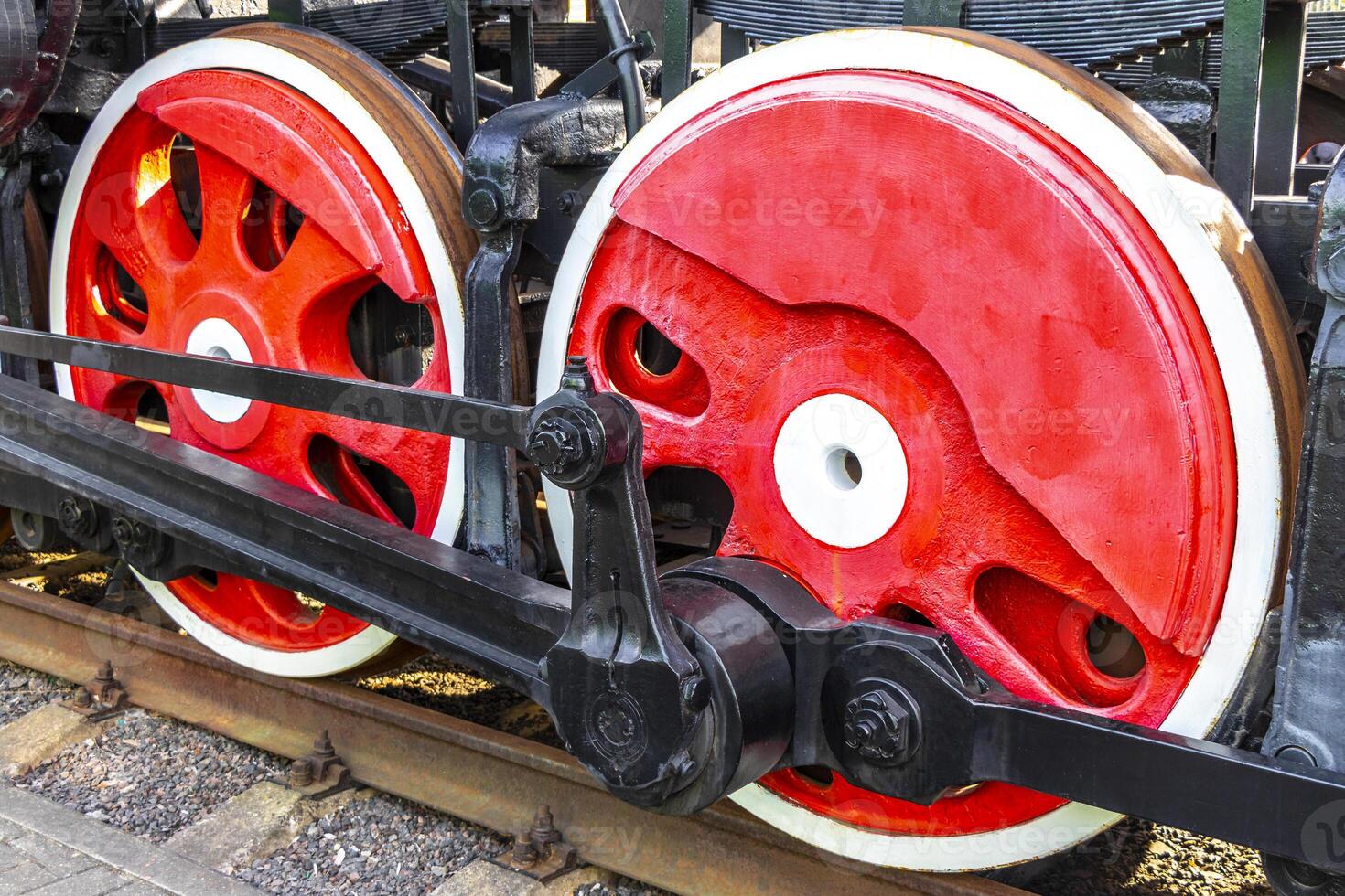 A close up of a train wheel with red and white spokes photo