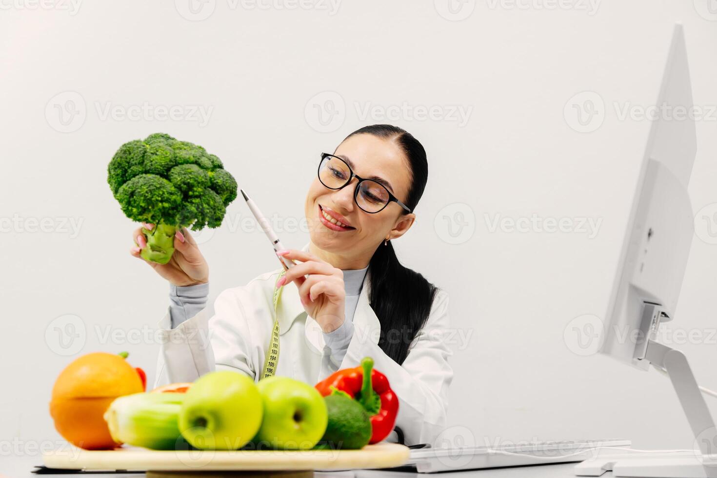 Nutritionist expert makes healthy balanced diet plate according to proportions of nutrients. Plate with fruits, vegetables on kitchen table. Concept of healthy eating, vegetarianism. White background photo