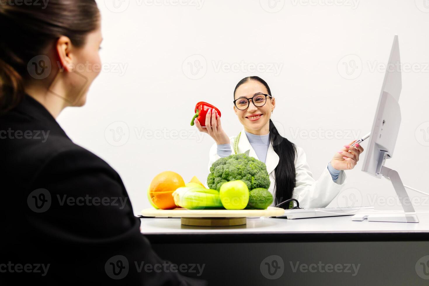 Female doctor and professional nutritionist in uniform advise Caucasian patient about supplementary foods and nutrients for healthy diet at clinic hospital, checkups, and appointments photo
