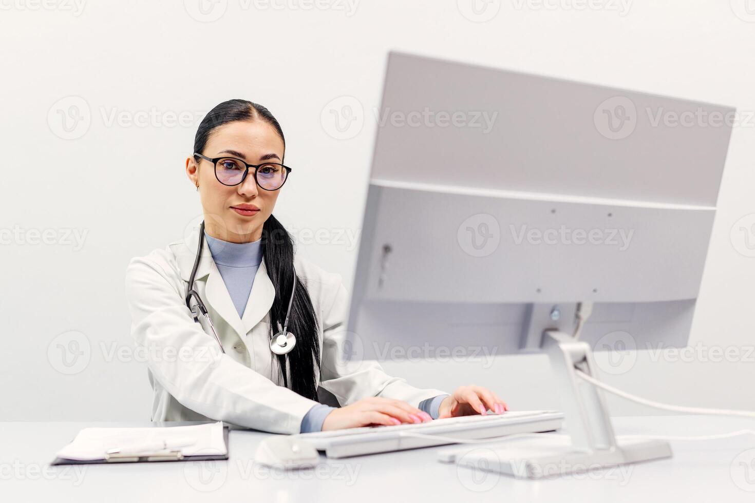 Portrait of young woman doctor in medical uniform. Concept of health care, helping patients. Health insurance expert looking at the camera on white background photo