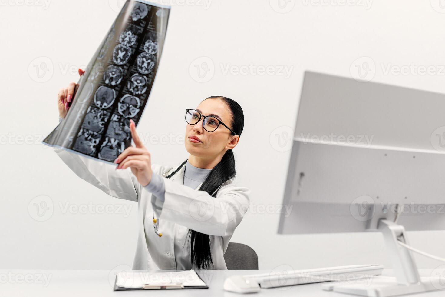 A female doctor analyzes an MRI or CT X-ray image of a patient in a radiology center at a computer. The concept of modern diagnostic methods. White background photo