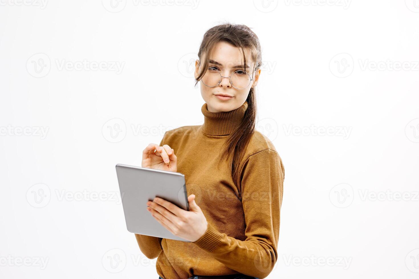 Young female employee wearing glasses, smiling and holding a digital tablet, on white background. Concept of business, successful work and modern technologies photo