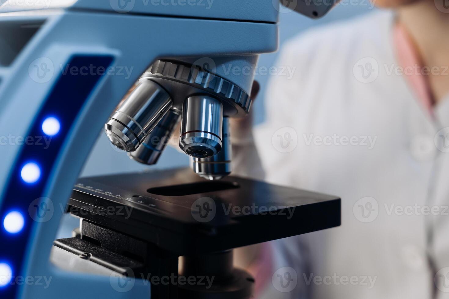 Scientist using microscope in laboratory, making medical testing and research, close-up. Biotechnology research in science lab. Microbiology equipment. Chemistry scientific concept. Ads, copy space photo