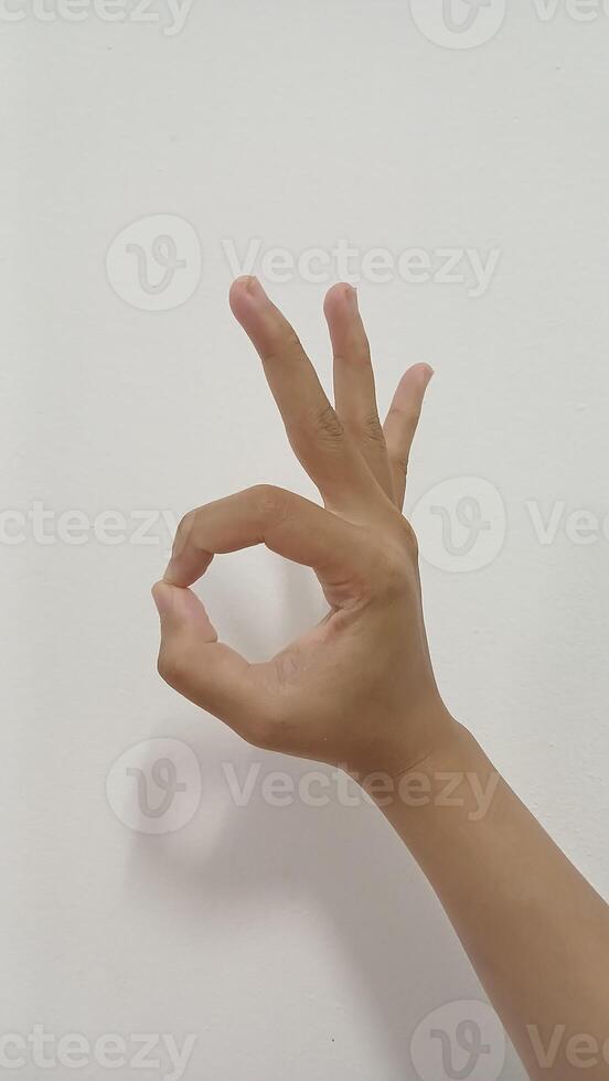 Closeup Asian female hand show pinch gesture made, Ok sign finger arm and hand isolated on a white background copy space symbol language okay photo