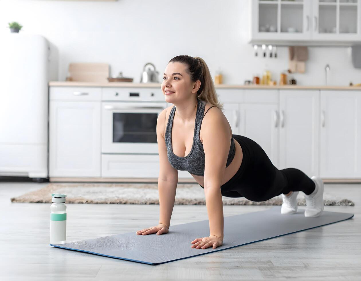 A plus-size woman taking a break from chores to do wall sits next to the kitchen, showing effort and discipline. photo