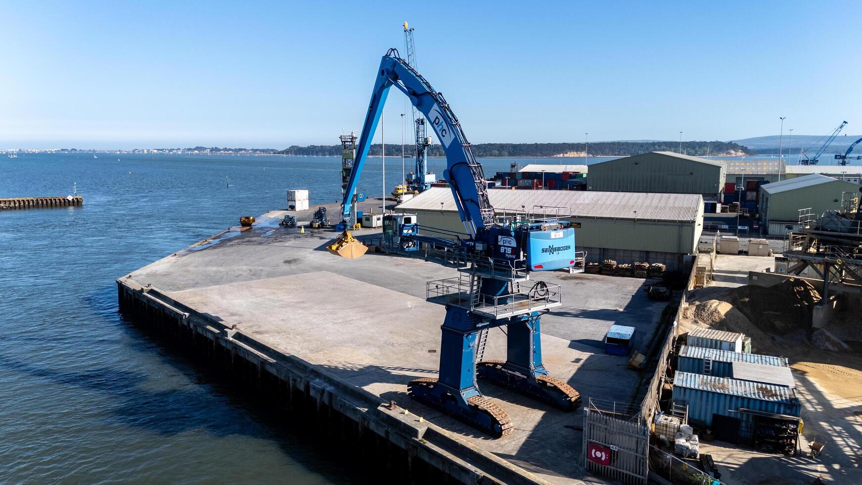 28 April 2025 Poole, Uk. Material handler unloading cargo in Poole Harbour, UK photo