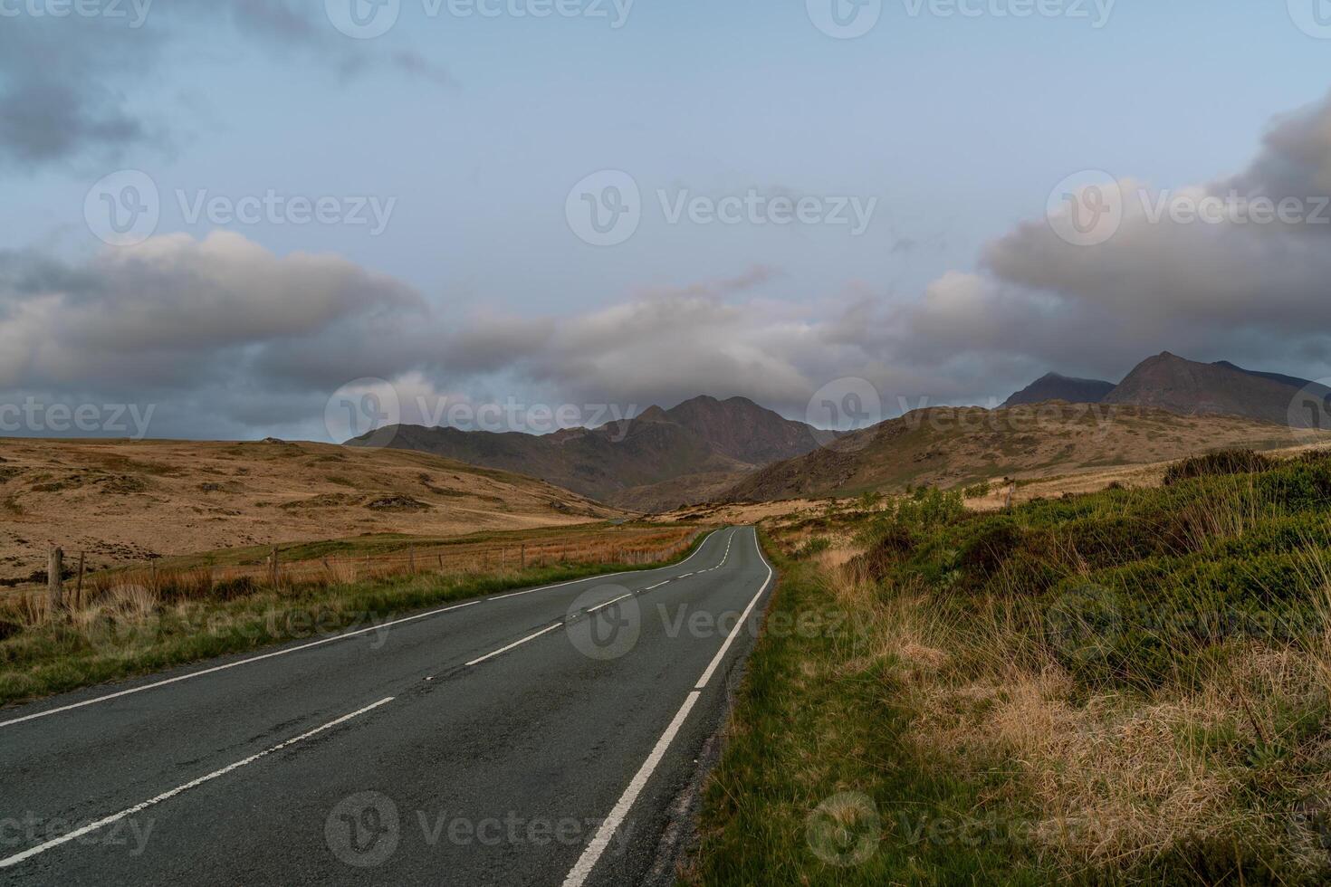 Scenic Road Leading to Snowdonia Mountains at Dusk photo