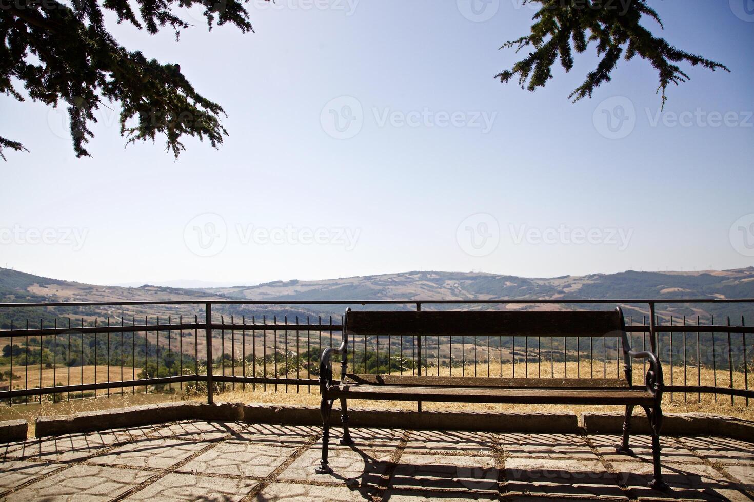 Bench on a panoramic terrace with hills in the background photo
