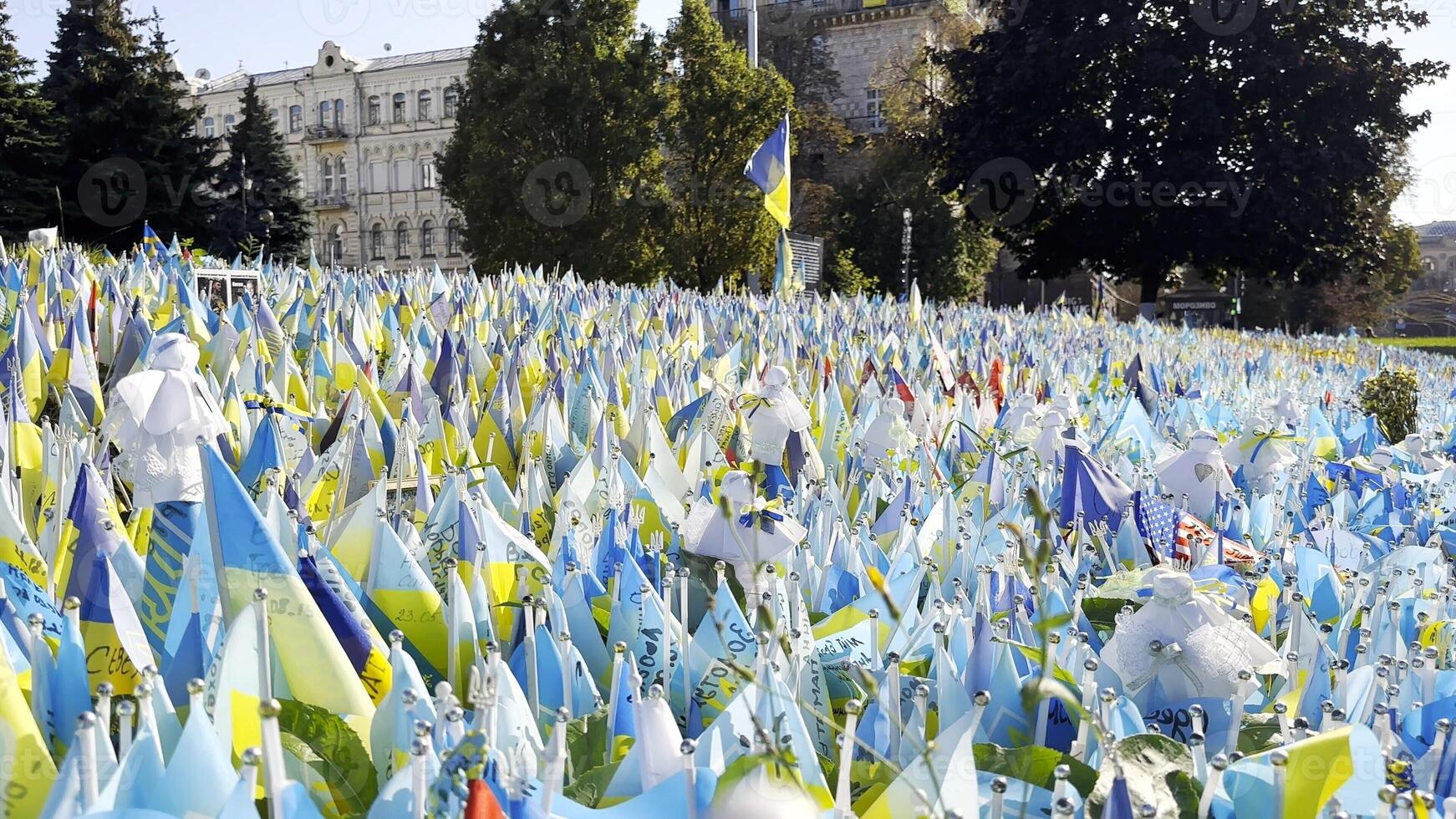 Many small blue-yellow flags with names of dead war against russia. Memorial of the fallen soldiers, children, women in the capital of Ukraine. Concept of tragedy and misfortune. Close up photo