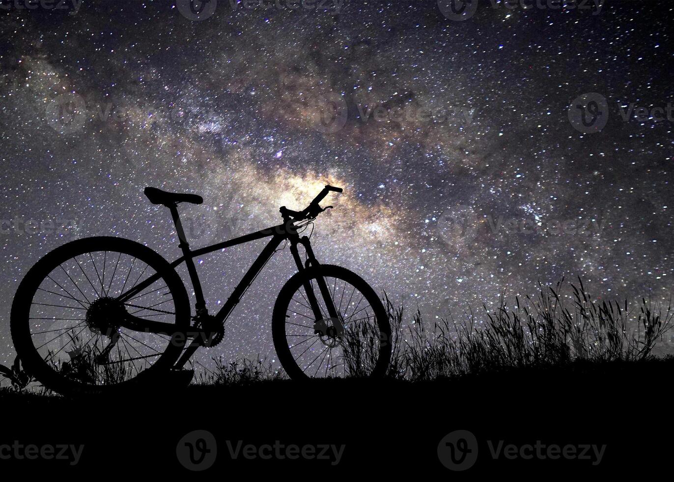 Silhouette of Mountain Bike Against Starry Night Sky with Milky Way in Background photo