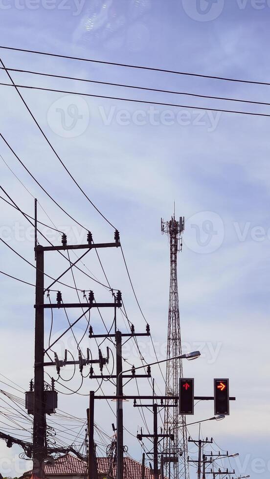 Urban Power Lines and Communication Tower Against a Clear Sky in a Cityscape Setting photo