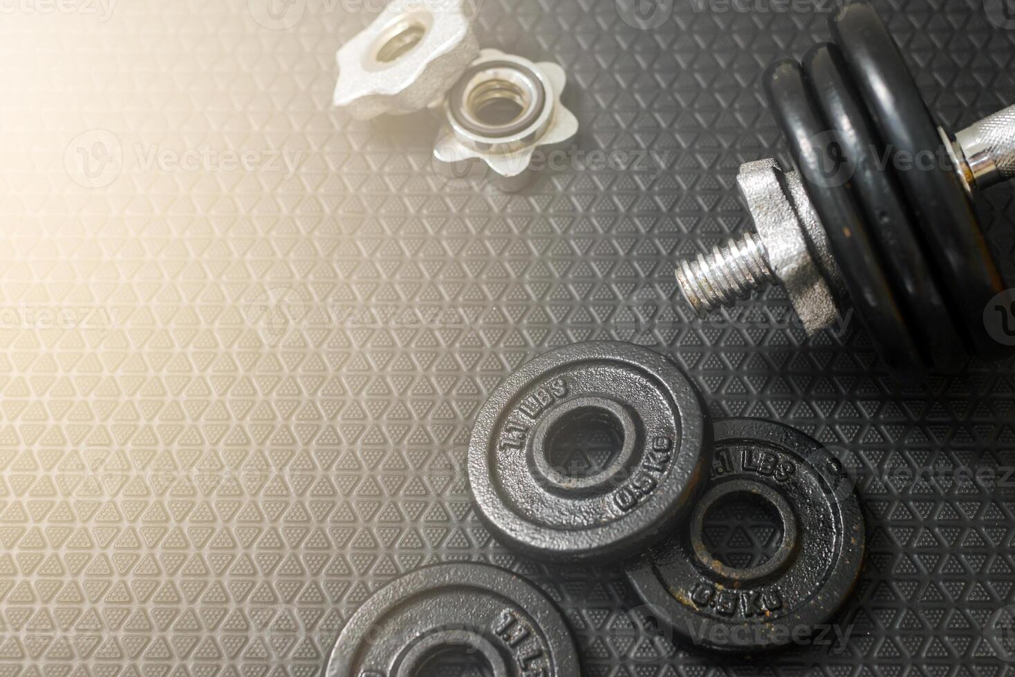 Iron dumbbells or weights on black floor with copy space for text. Health care concept photo