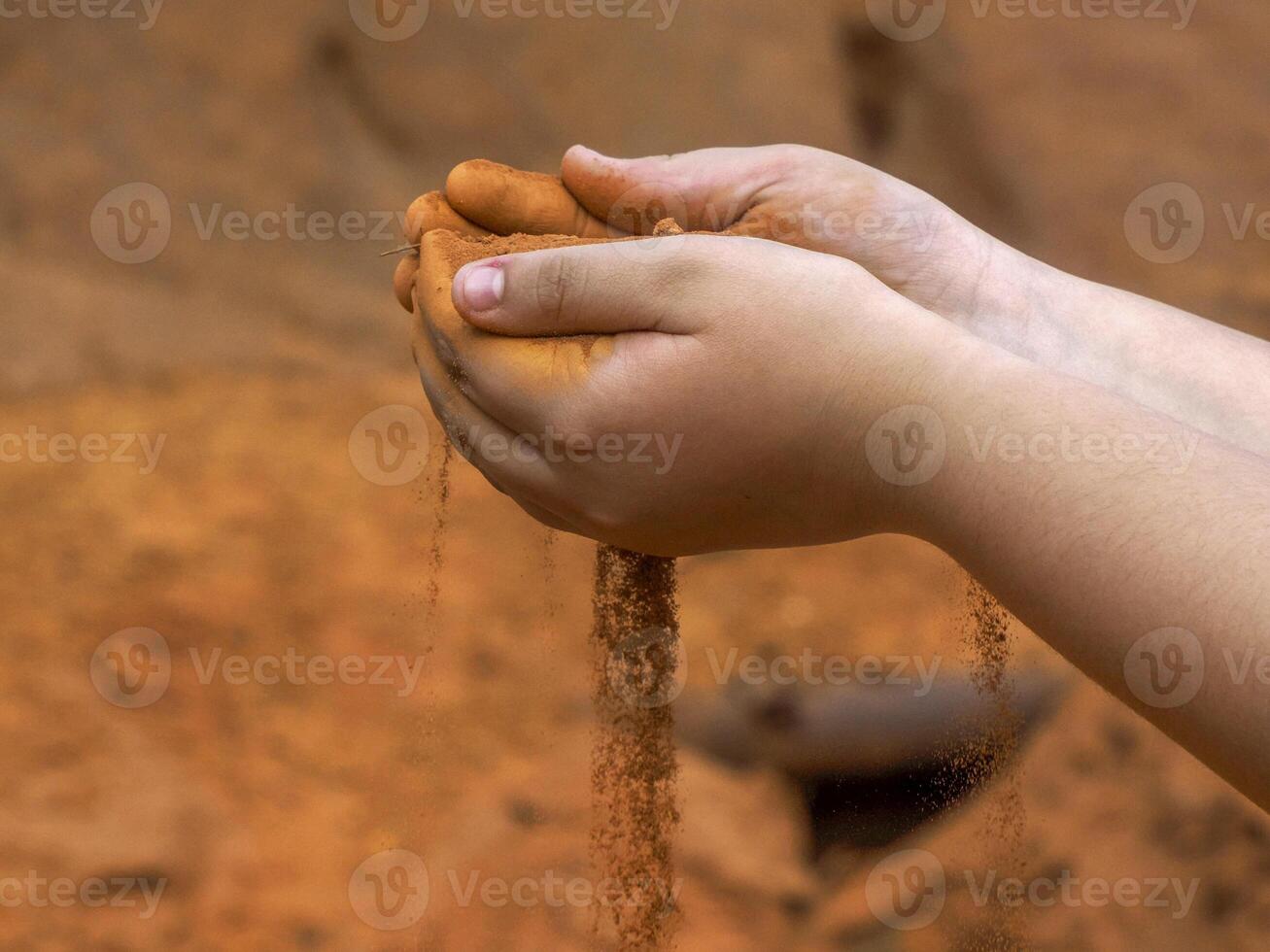 Hands of a young girl spreading red soil in Colorado Ocher canyon valley massif in Provence france photo