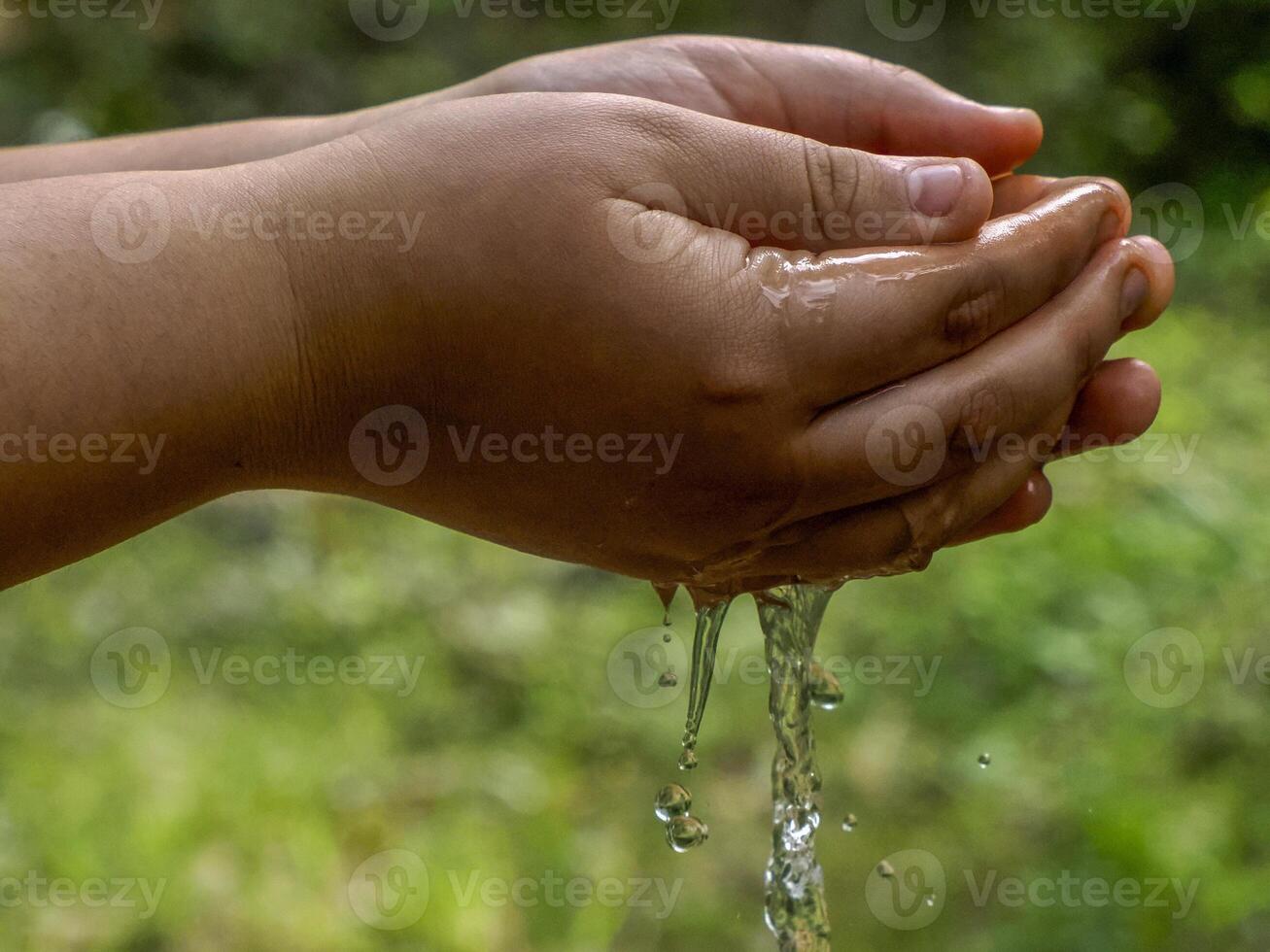 Hands of young girl spreading water in Colorado Ocher canyon valley massif in Provence france photo