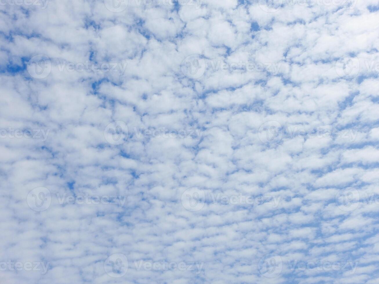 A plane flying in the sky with some clouds photo