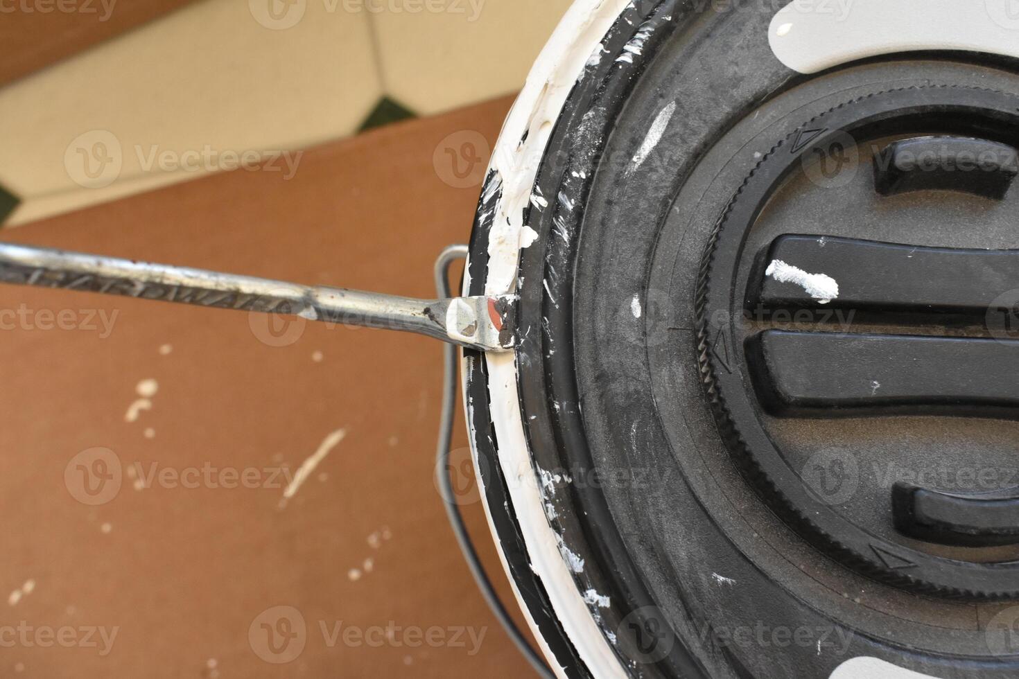 Opening a Can of Paint with a Metal Paint Key During a Home Remodel photo
