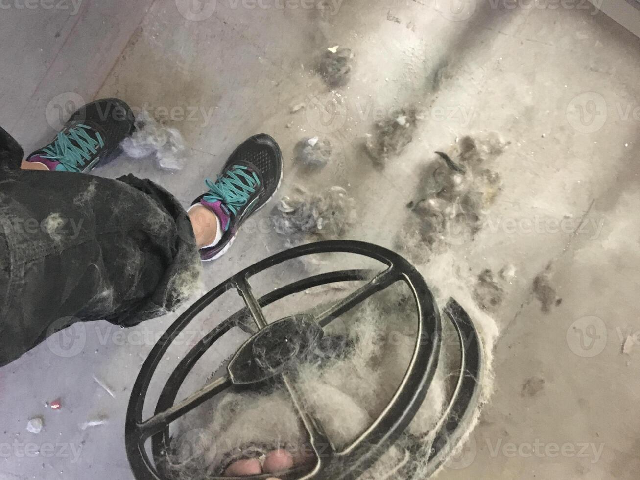 Holding a Filter Full of Pet Fur in a Grooming Salon, Overflowing Mess on Floor photo