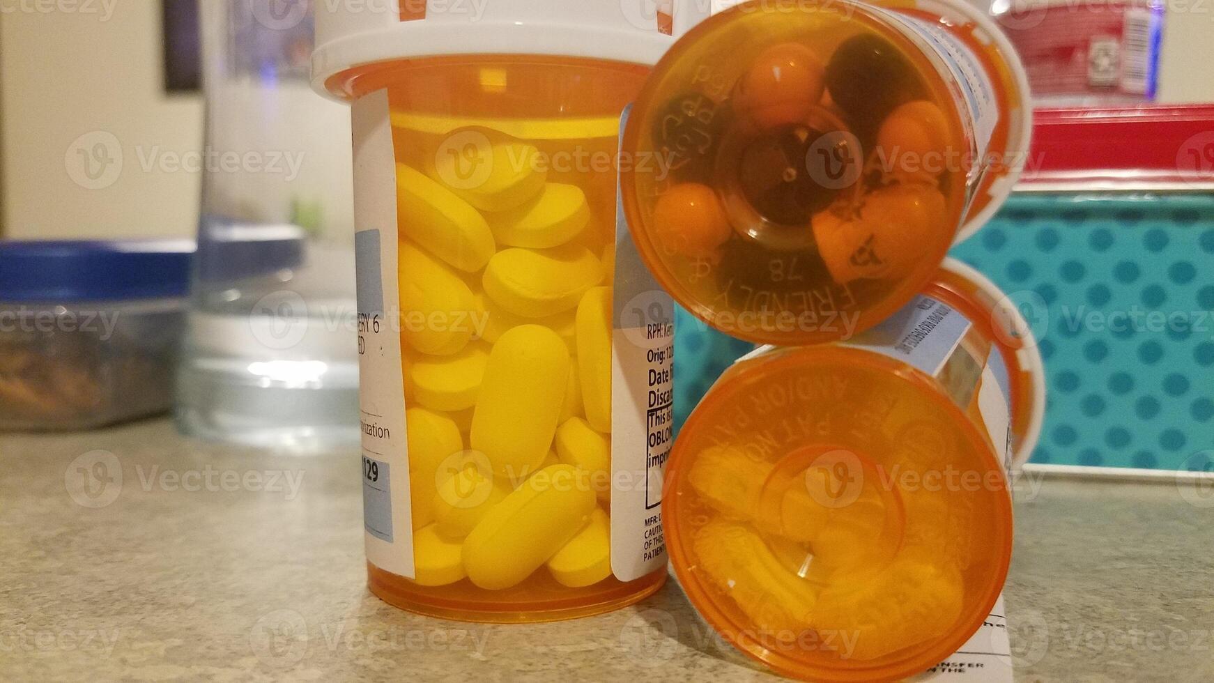 Prescription Medicine Pills in Plastic Orange Containers near Water Glass photo