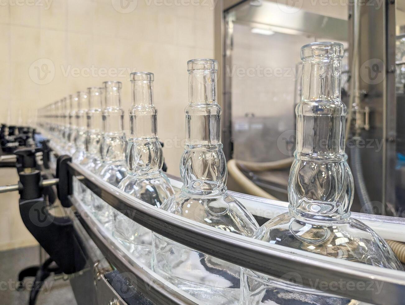 Empty glass bottles on conveyor belt in modern factory production line photo