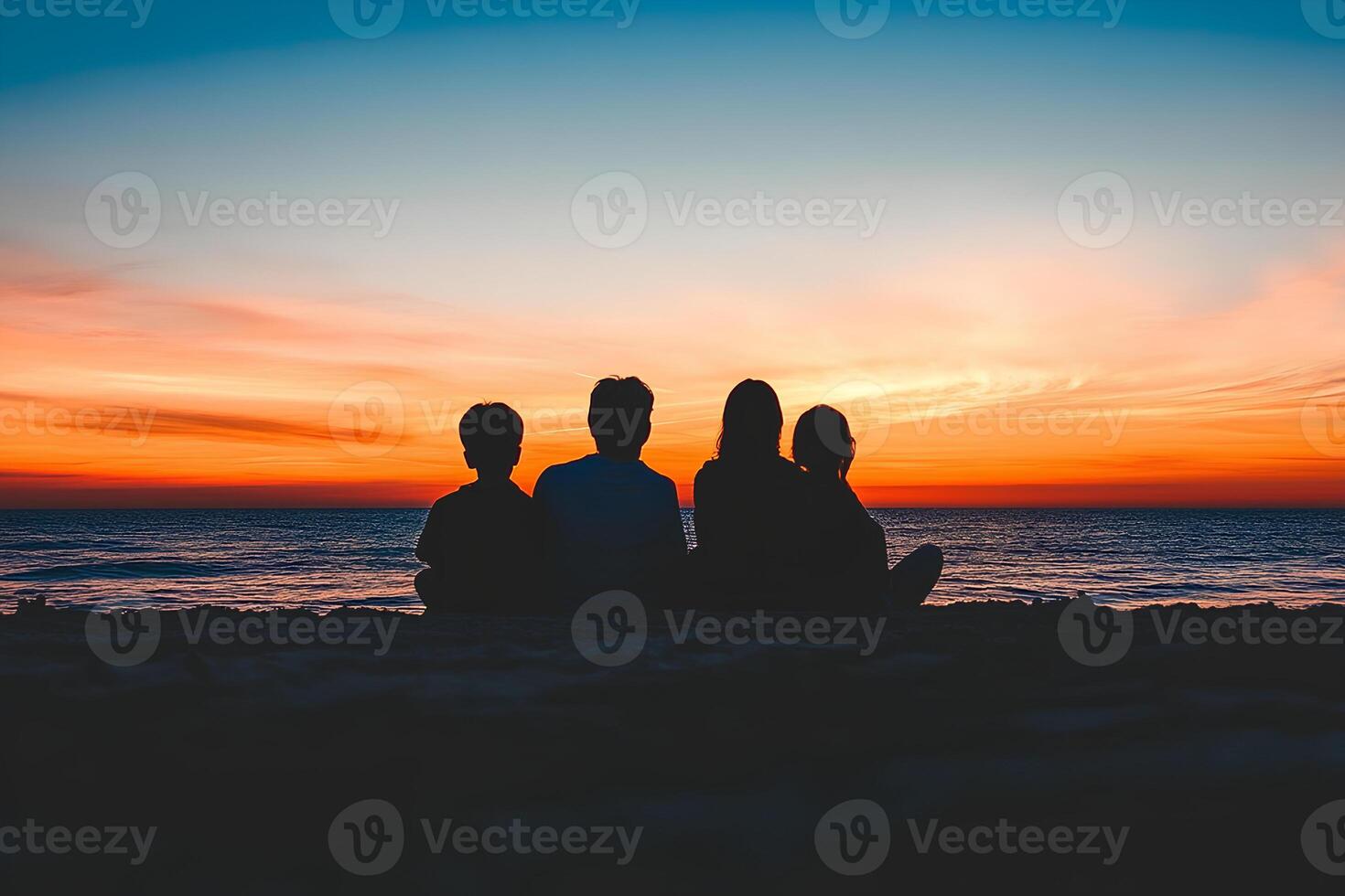 A peaceful silhouette of a family of four sitting together on the beach, enjoying the beautiful sunset, creating a heartwarming scene of togetherness and tranquility photo