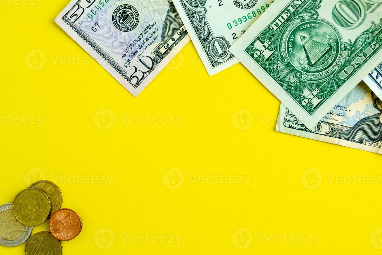 Dollars and euro coins on a yellow background, background with copy space. photo
