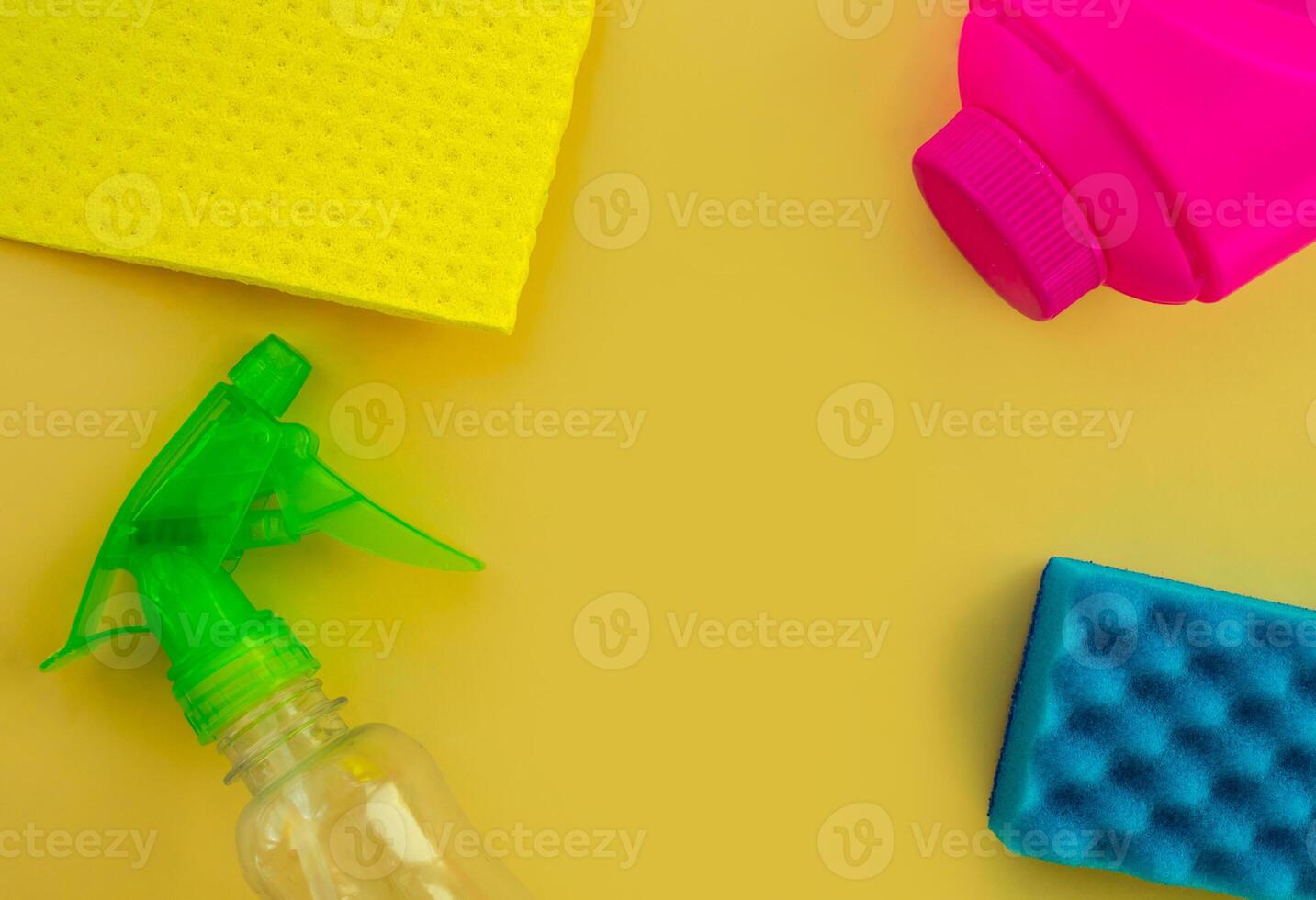 Cleaning. Flat lay Bottles with cleaning product and sponges on a yellow background, empty space in the center. photo