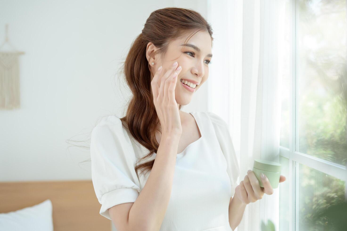 Woman Enjoying Natural Skincare in a Bright, Minimalistic Room Surrounded by Greenery photo