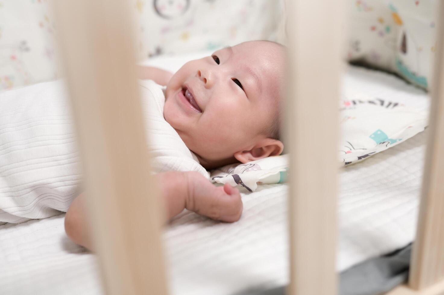 Baby Smiling and Playing in a Crib During Morning Time at Home With Calm Ambiance photo