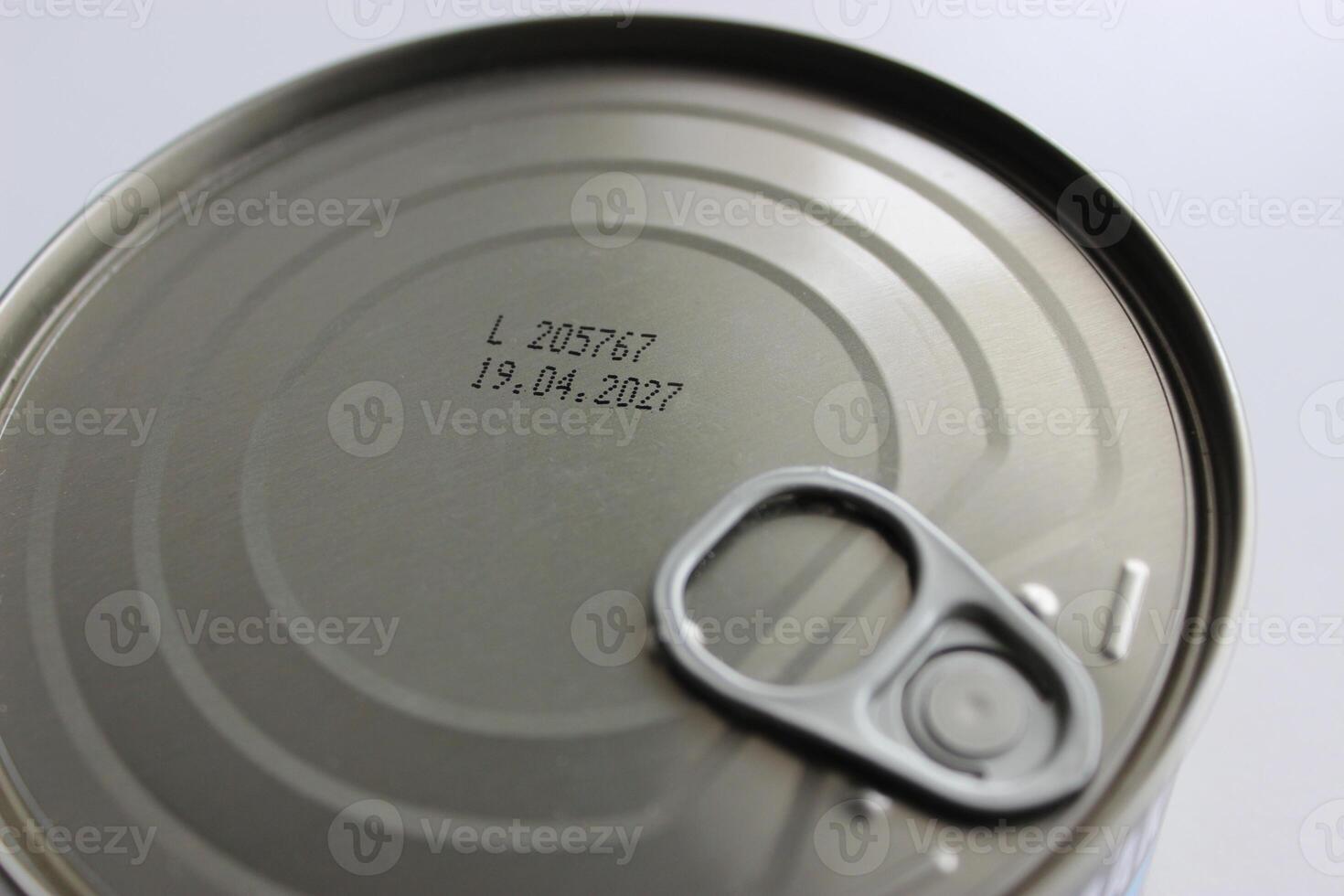 Top part of sealed tin of canned meat with an expiration date of 2027 isolated on white photo