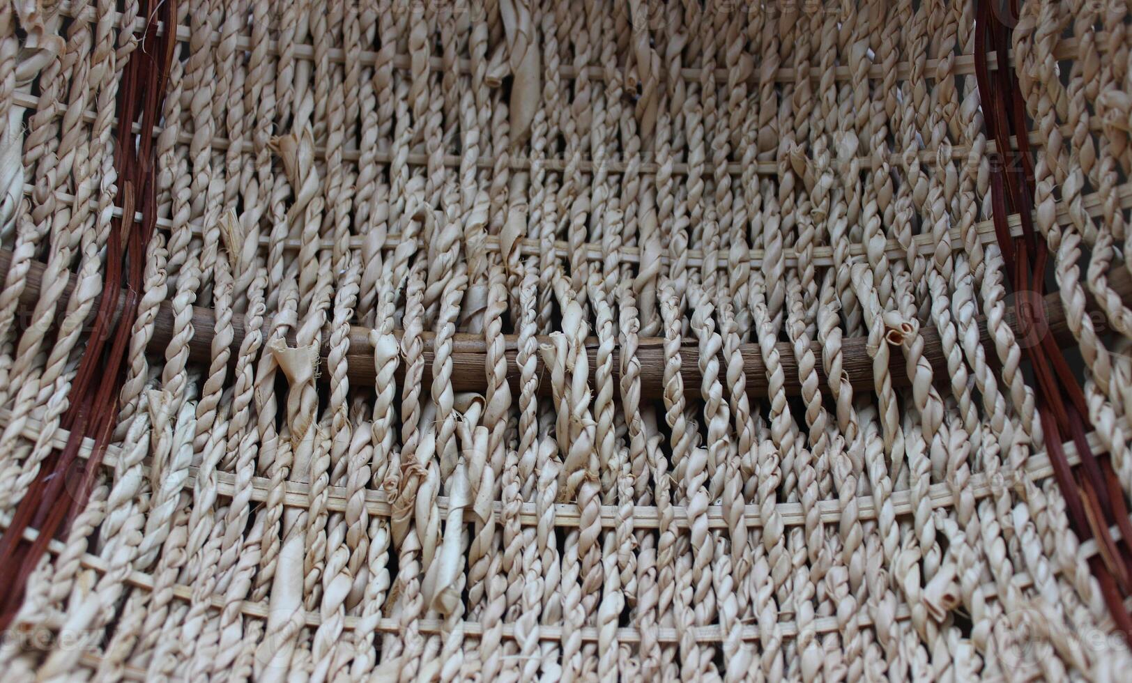 The bottom of a round craft basket woven from braided willow twigs photo