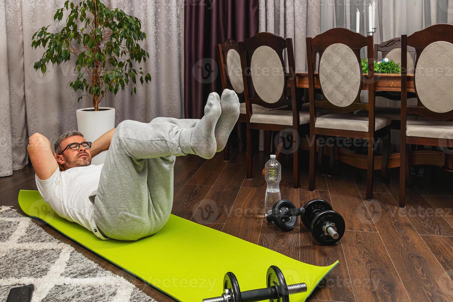 Man exercising at home on yoga mat during indoor workout photo