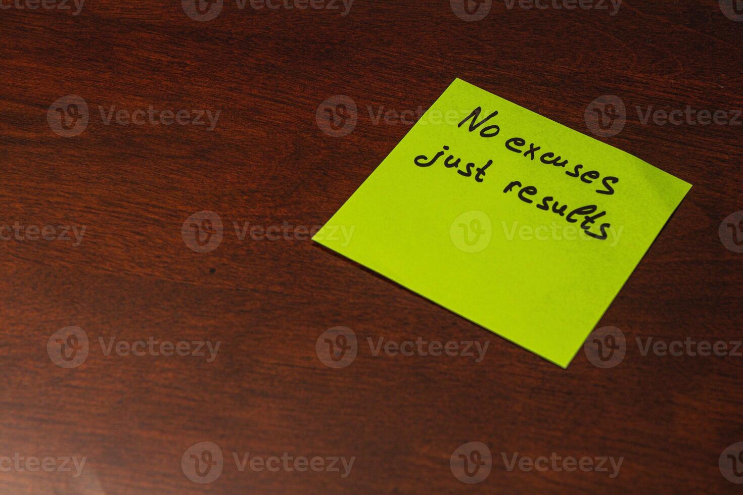 Motivational note on bright sticky paper placed on a wooden desk photo