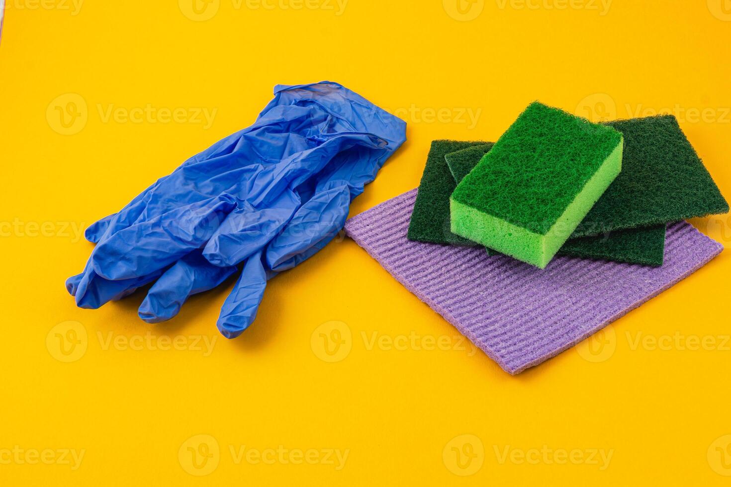 Cleaning supplies arranged on a vibrant yellow background photo