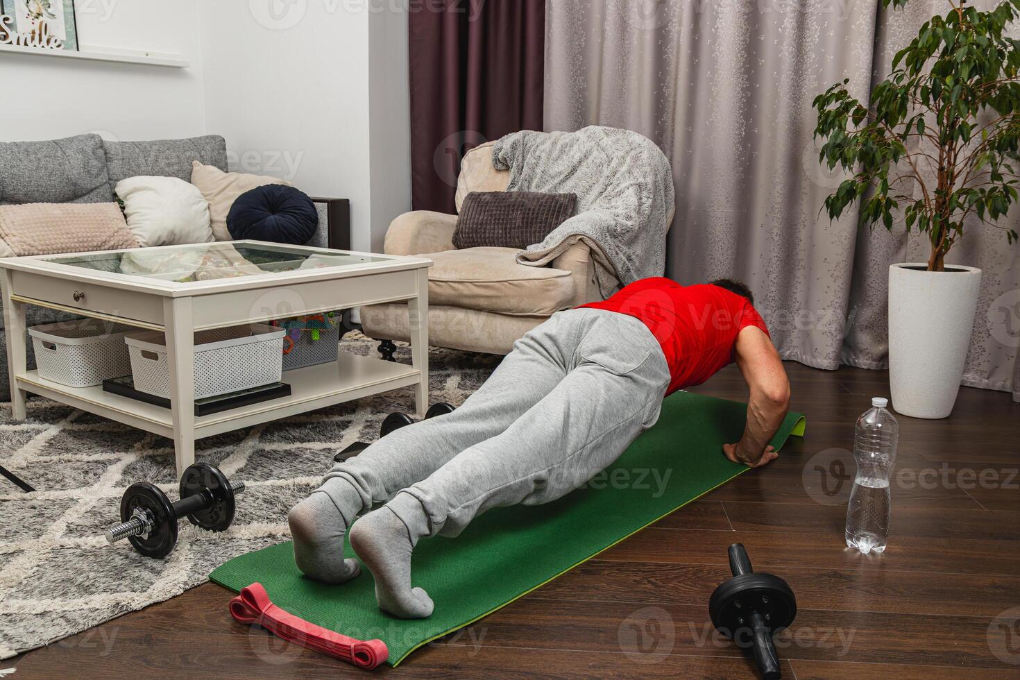 Man exercising indoors with push-ups on a mat photo