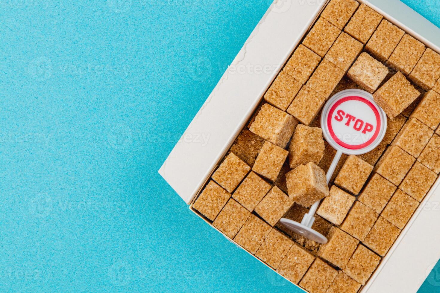 Creative arrangement of sugar cubes with a stop sign on a blue background photo