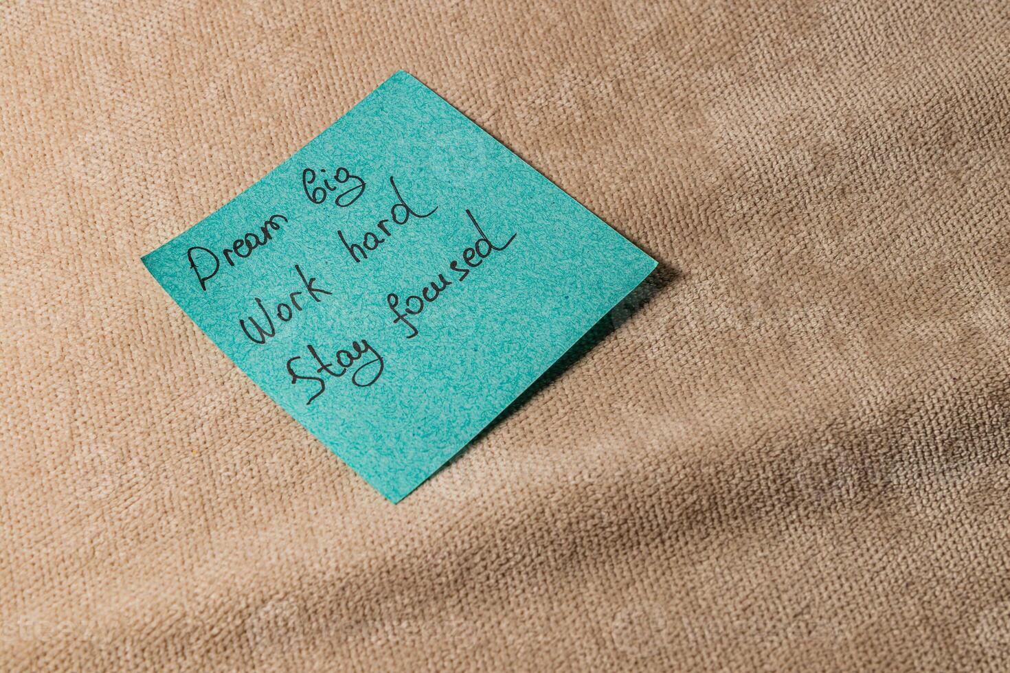 Motivational sticky note encouraging focus and hard work on a soft surface photo
