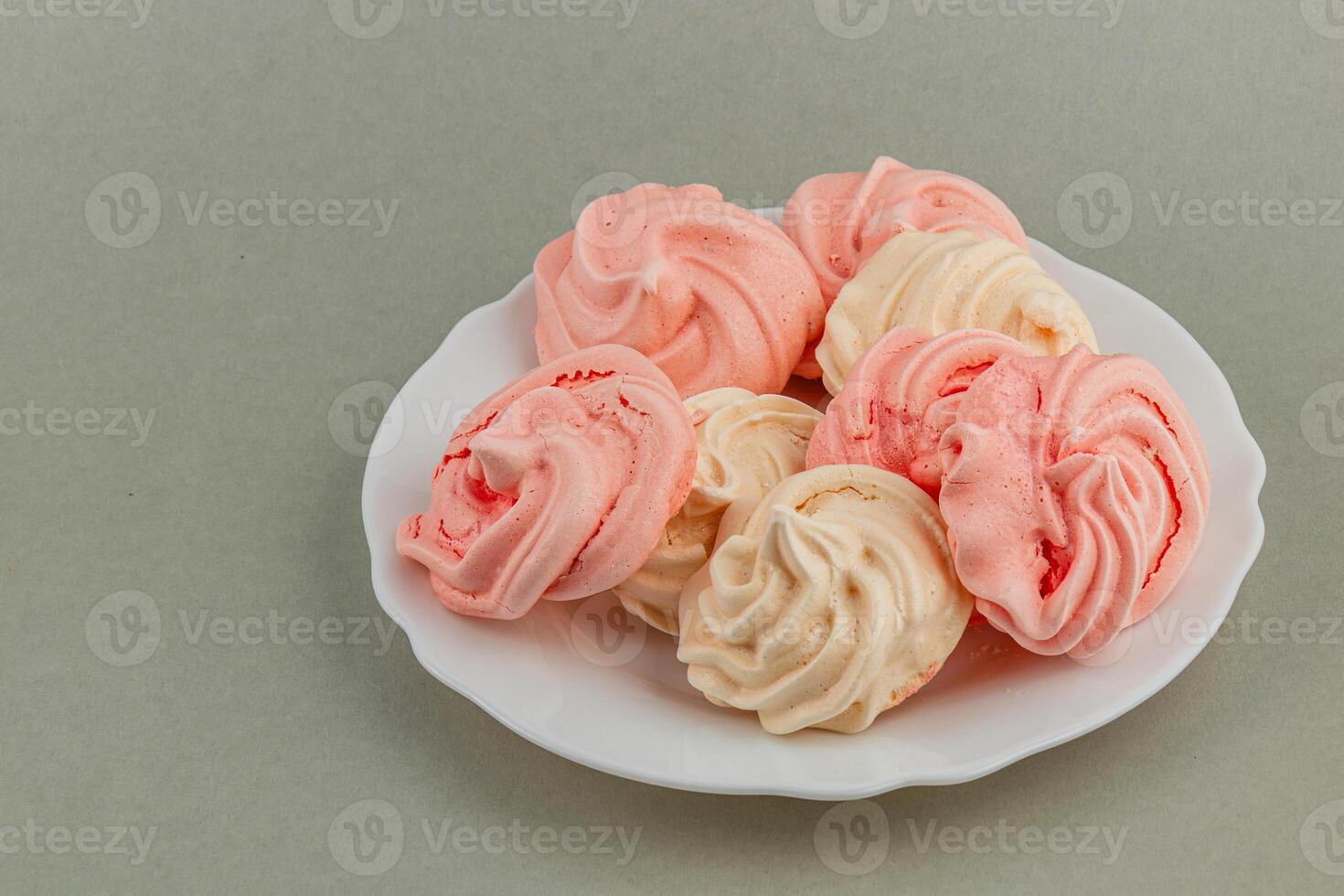 Colorful meringue cookies arranged on a white plate photo