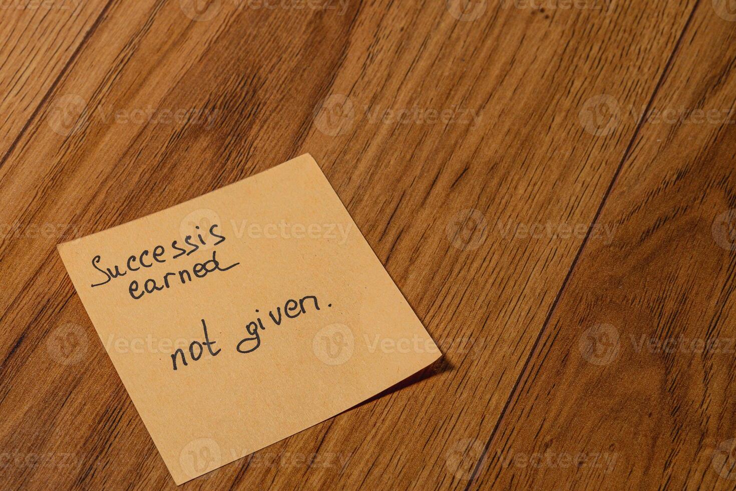 Inspirational note on wooden floor emphasizing the value of success photo