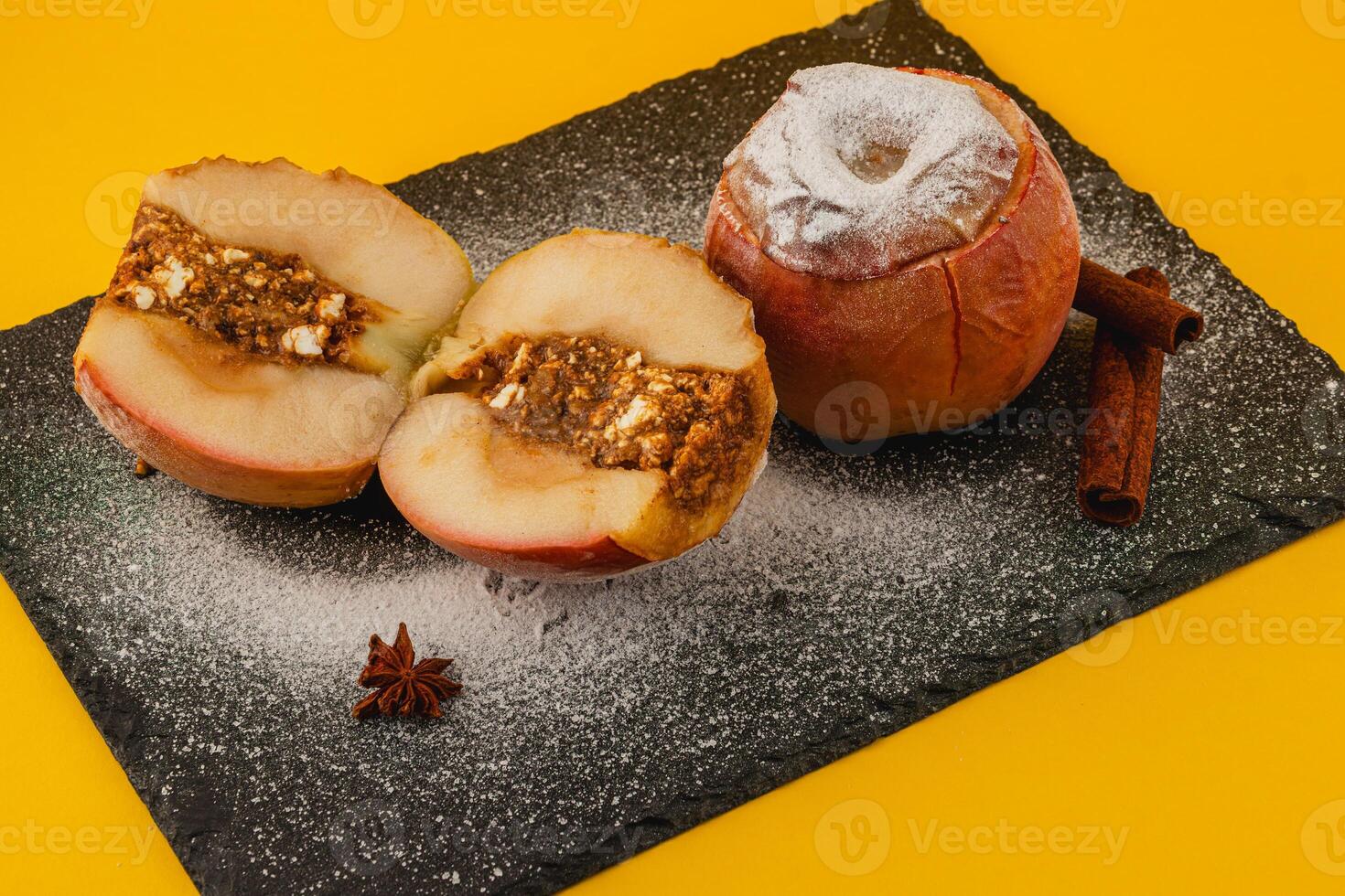 Baked apples with cinnamon and nut stuffing on a black slate photo