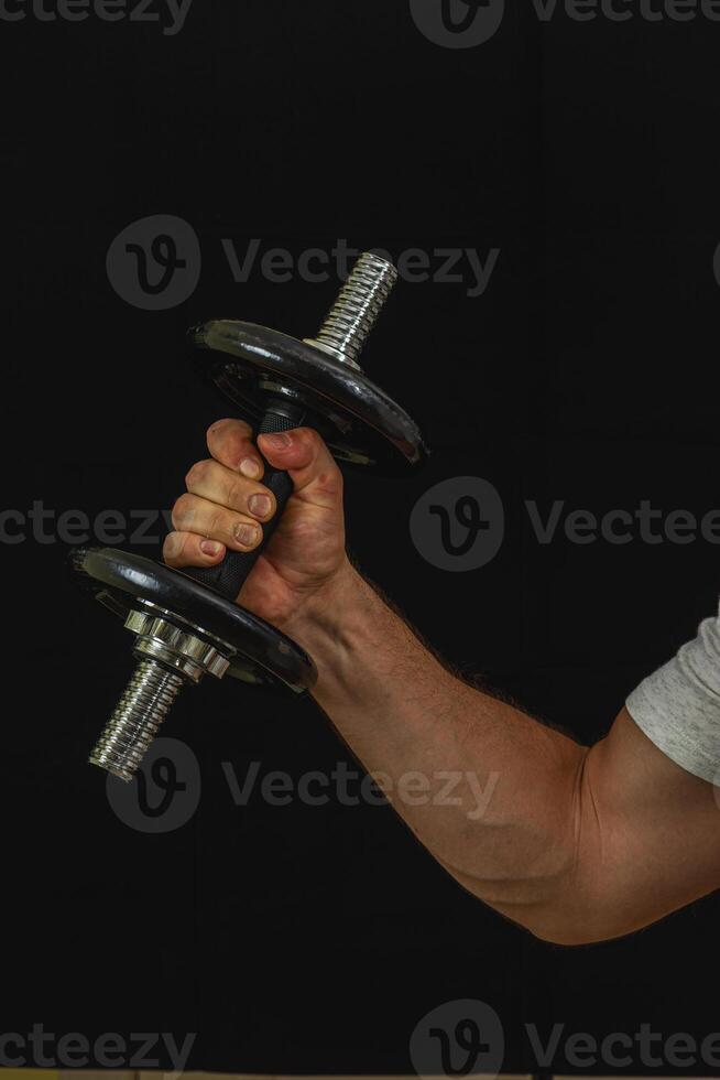 Weightlifting exercise in the gym with a dumbbell photo