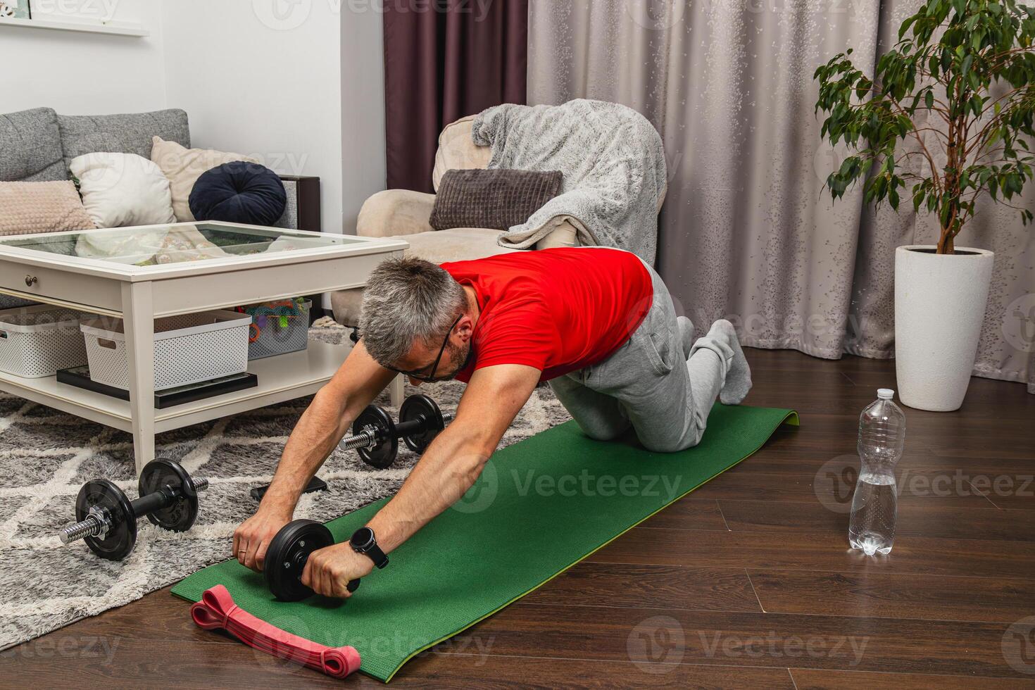 Man training with ab roller in living room photo