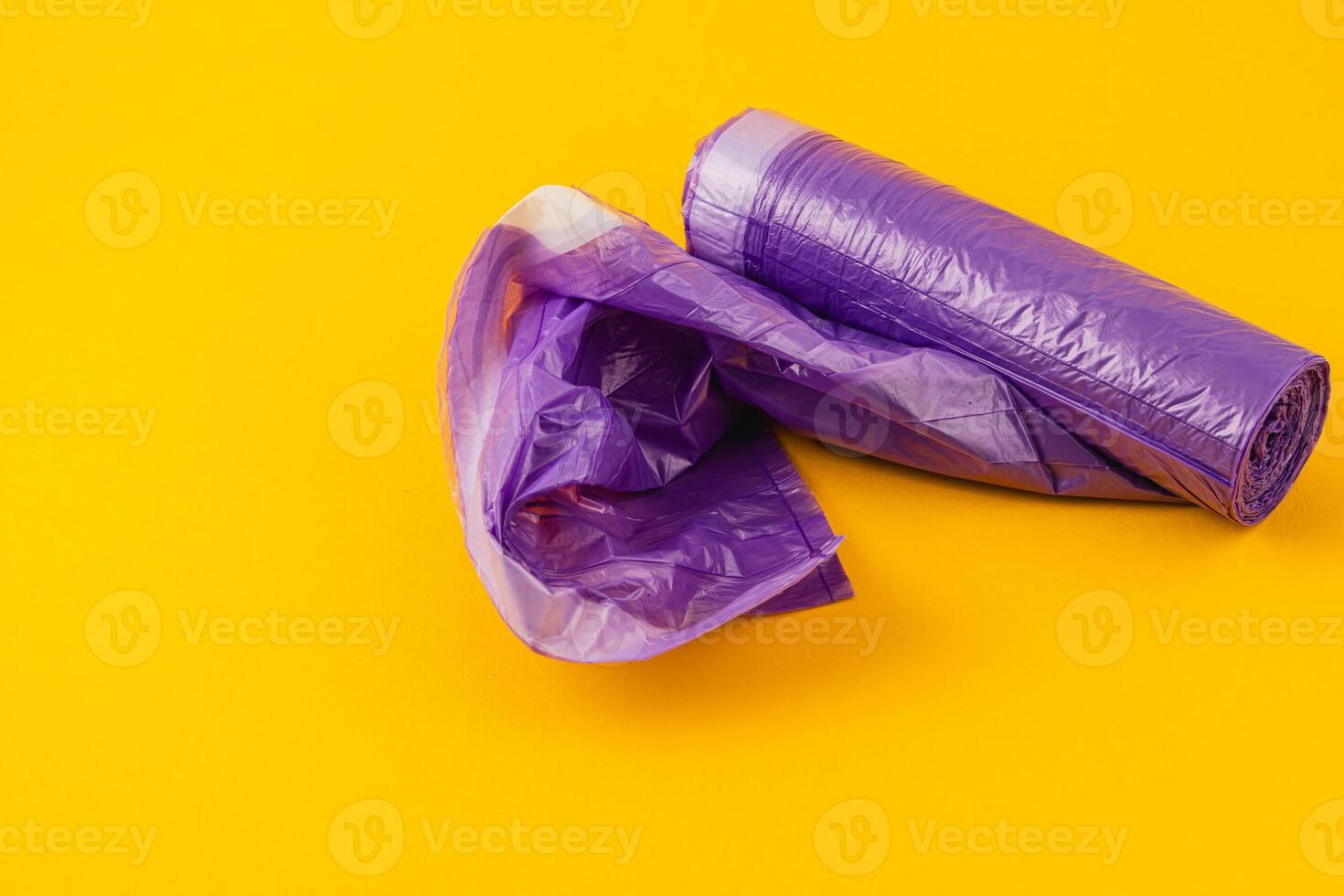 Purple plastic rolls displayed on a bright yellow background photo