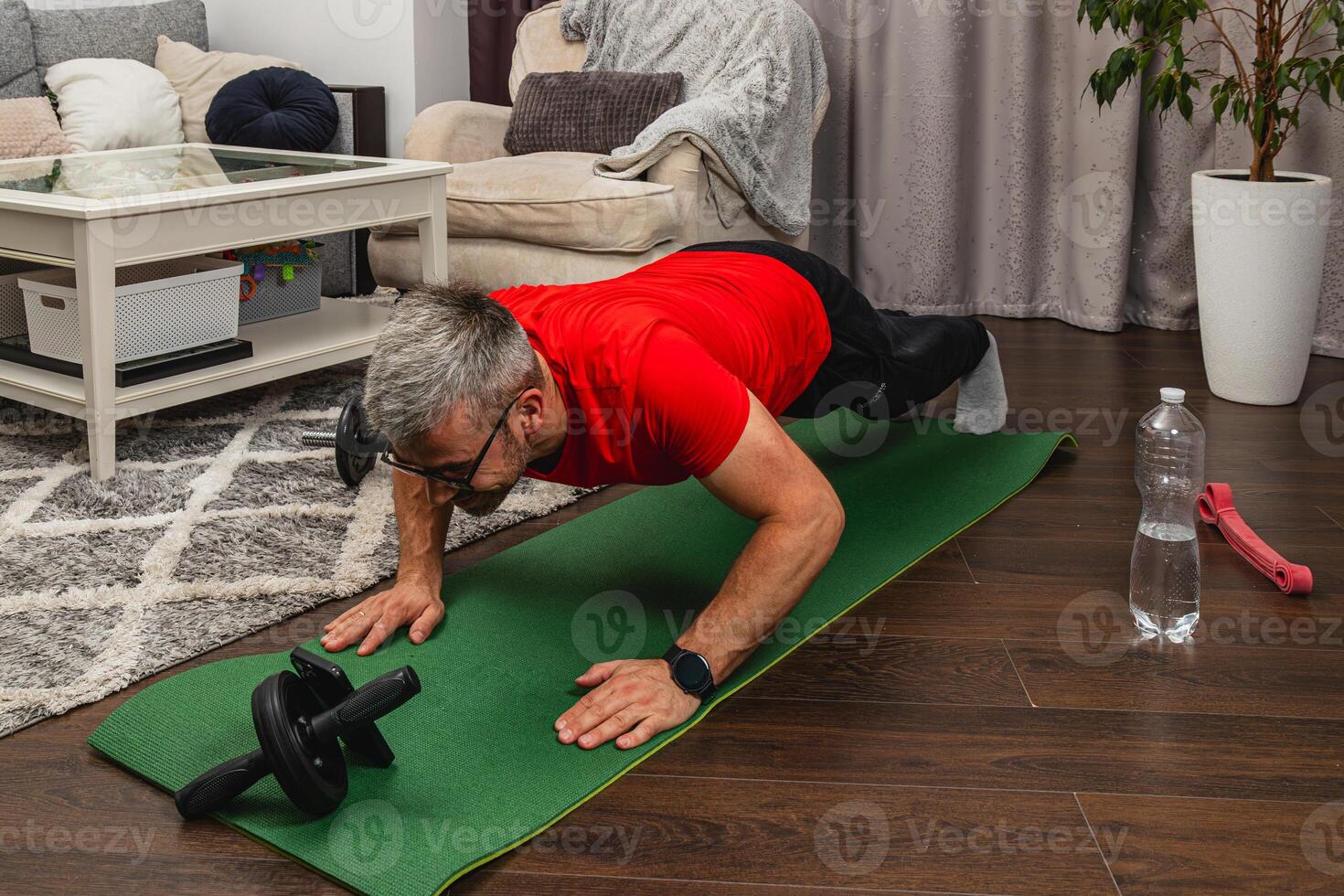 Man exercising at home with push-ups on mat photo