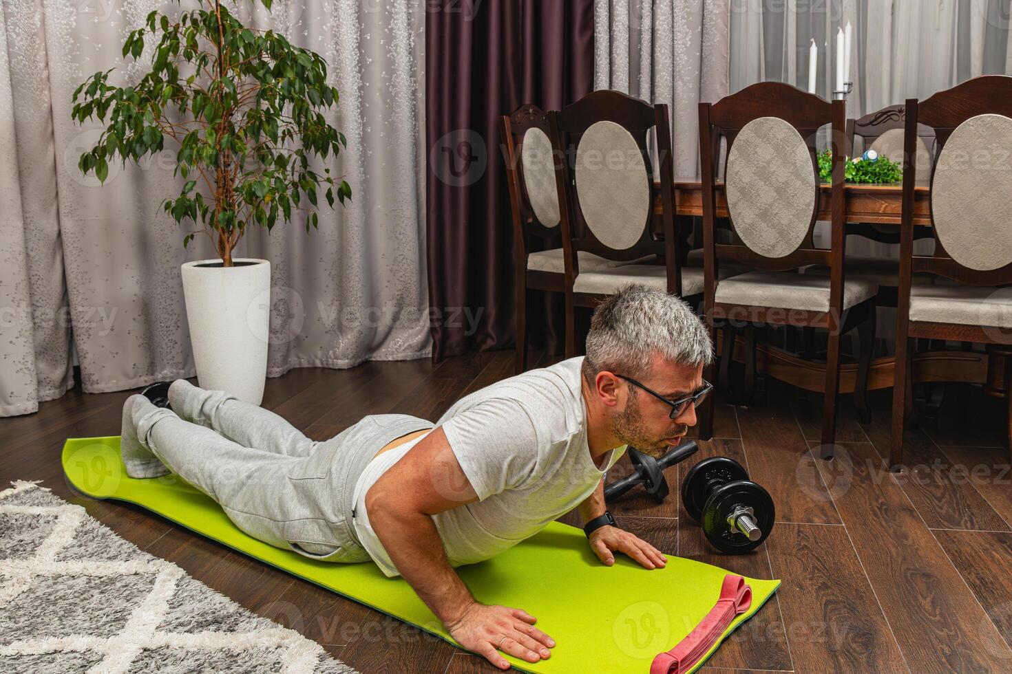 Man exercises at home using a fitness mat photo