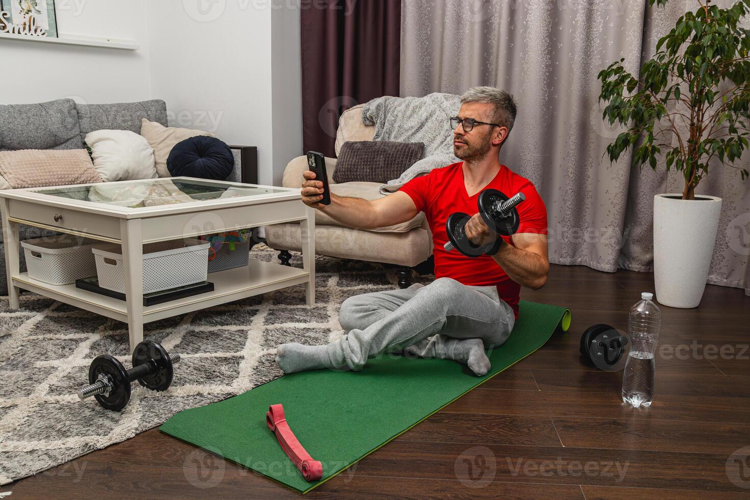 Man exercising at home while monitoring progress photo