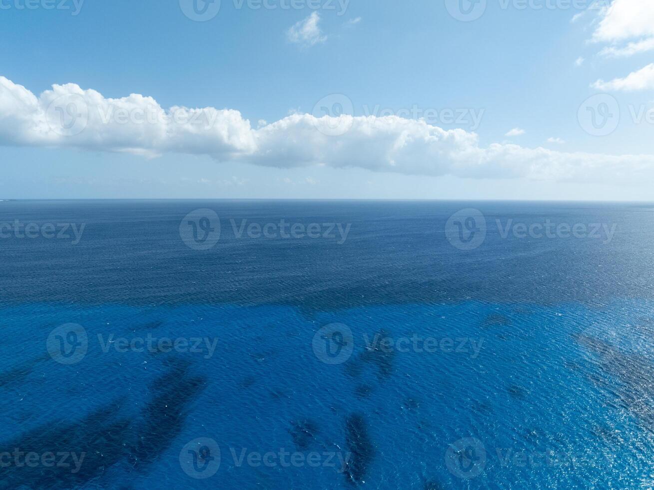 A blue ocean with a few clouds in the sky photo