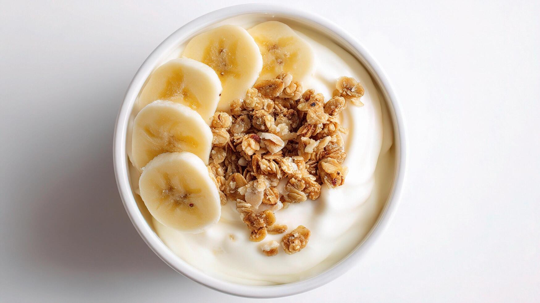 A bowl of yogurt topped with bananas and granola photo