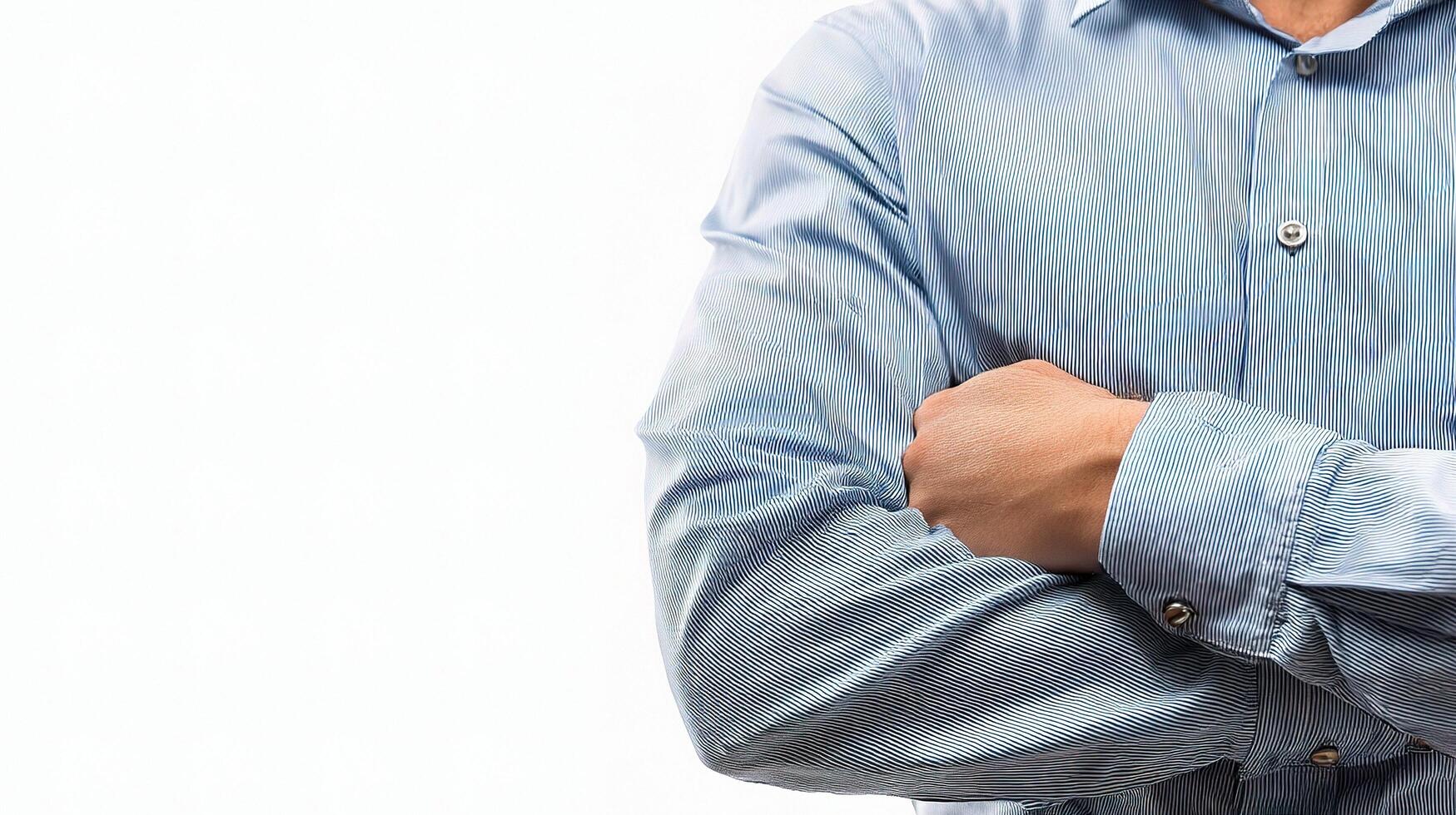 A man in a blue shirt with his arms crossed photo
