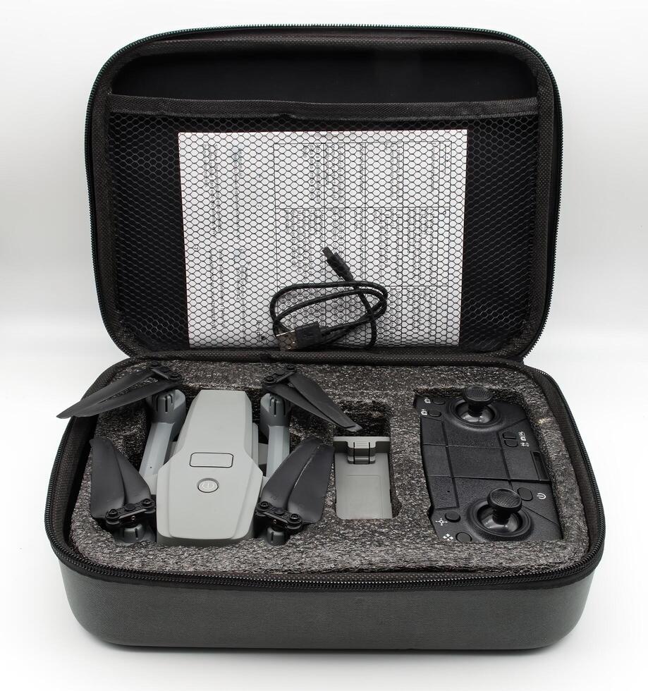 A gray drone and remote control are neatly arranged inside a black protective case. photo